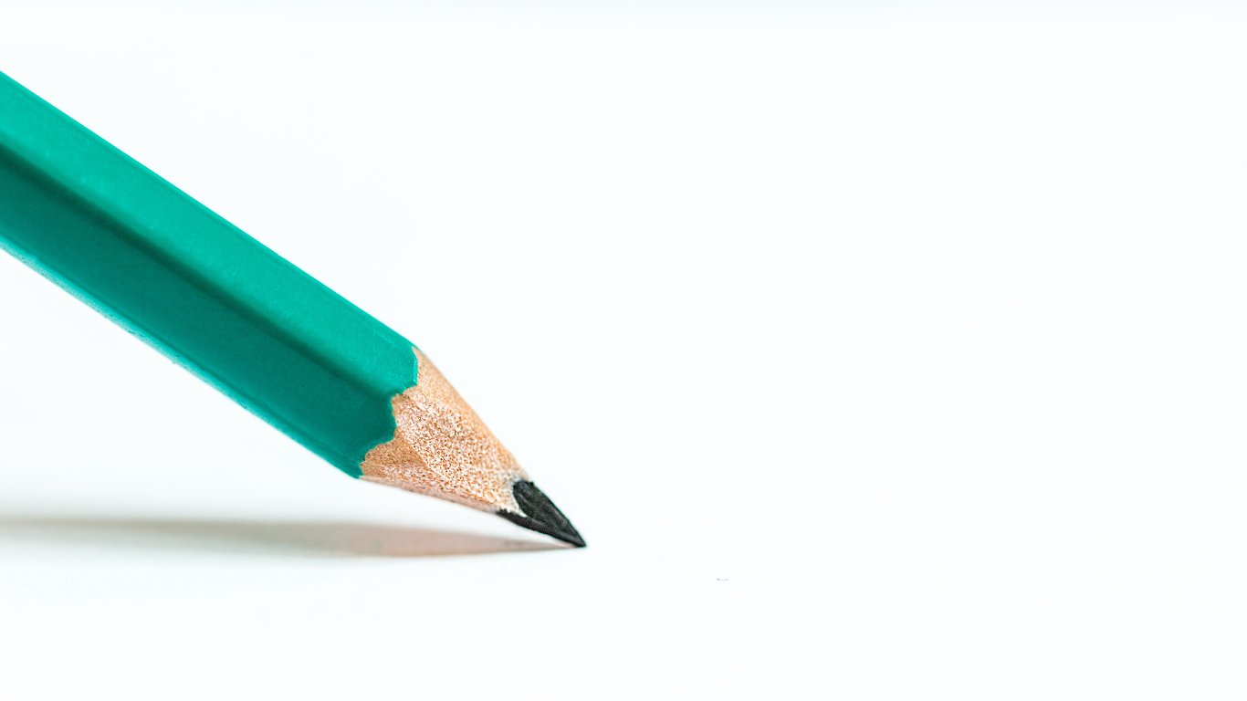 Close-up of a sharpened green pencil on a white background.