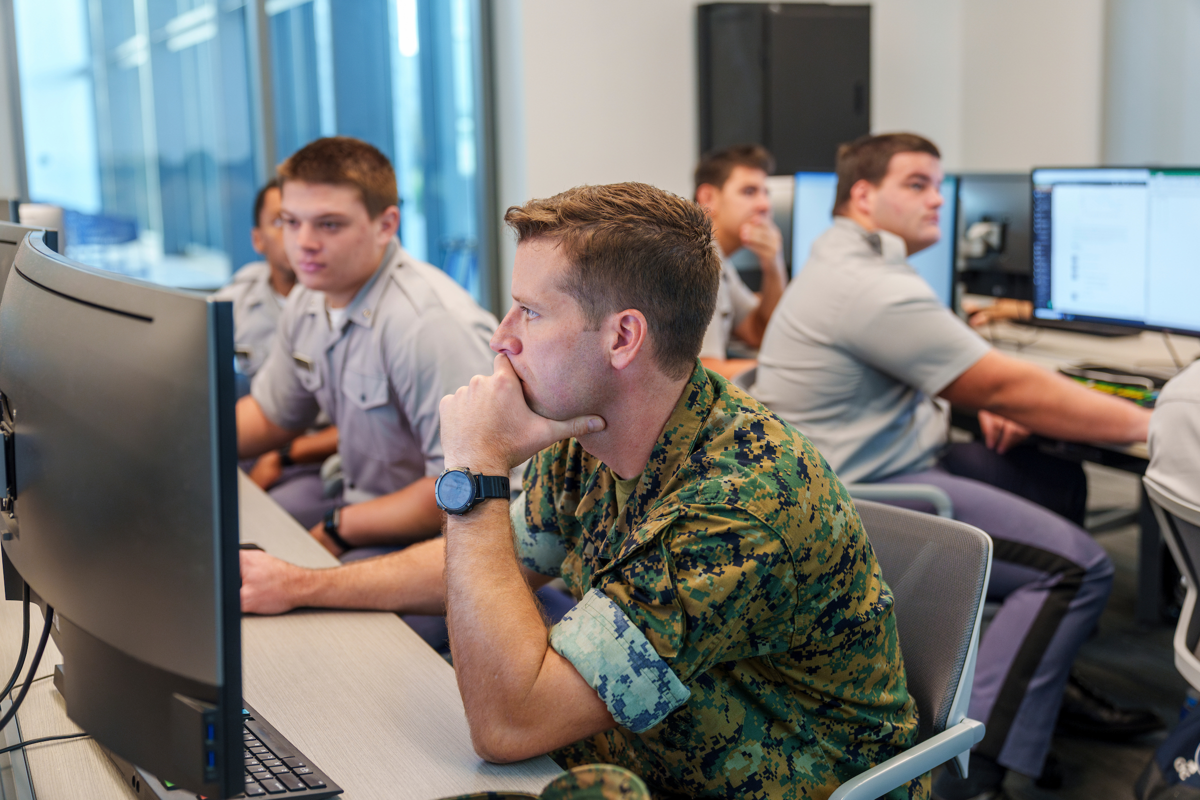 Active duty student and cadets work at computers during a classroom exercise.